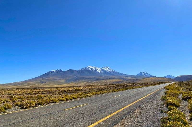 Sceneries of the empty road with mountains in the background while driving in Chile, photo by Next Level of Travel