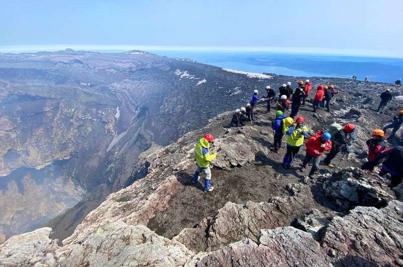 Villarrica volcano in Chile, hikers at the top of the volcano wearing gas masks, photo by Next Level of Travel