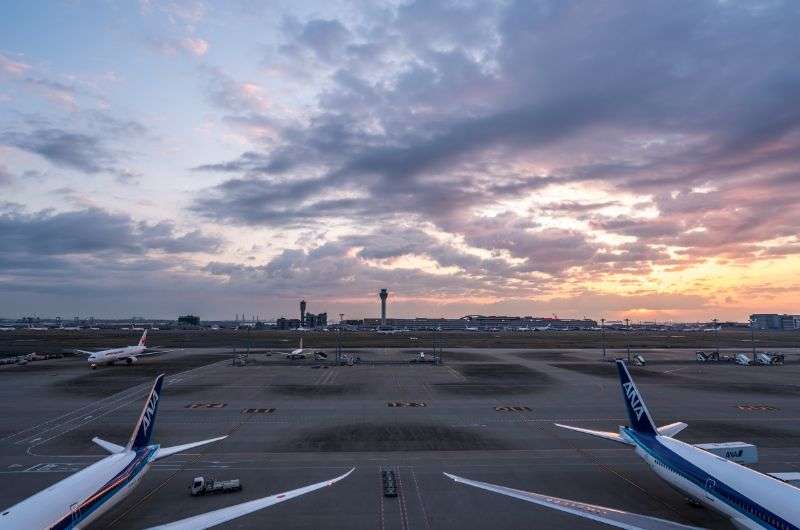 View from Haneda Airport terminal to planes on runway, sunrise in TOkyo Japan