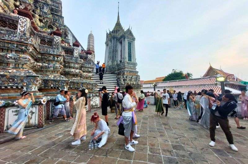 Tourists taking photos at Wat Arun in traditional Thai clothing, Bankok itinerary, photo by Next Level of Travel