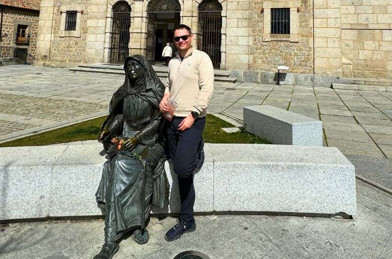 A traveler taking picture with the Saint Theresa statue in Ávila, Spain, picture by Next Level of Travel