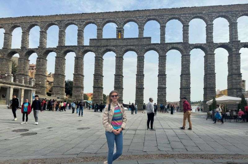 A tourist in front of the Segovia Aqueduct, Spain, photo by Next Level of Travel