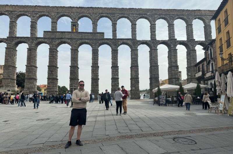 A tourist in front of the Segovia Aqueduct, photo by Next Level of Travel