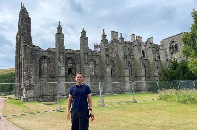 A tourist in front of the Holyrood Palace, one day in Edinburgh, photo by Next Level of Travel