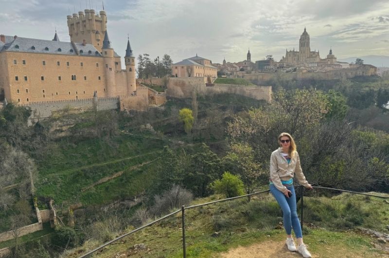 Tourist at a viewpoint above Segovia with the castle and cathedral in view, photo by Next Level of Travel