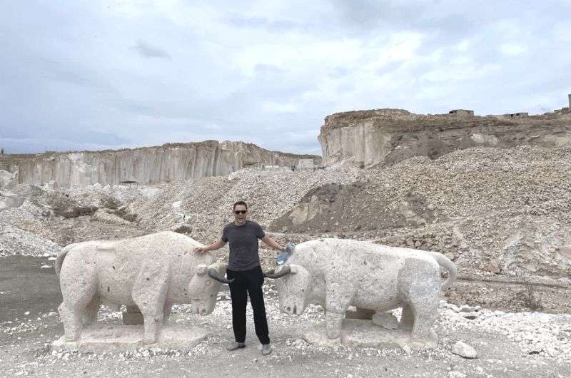 traveler between two bull statues, Peru’s White City, photo by Next level of travel